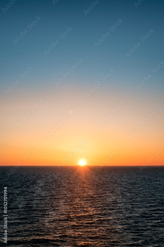 Baltic sea at sunset. Clear sky with glowing golden sun, reflections in the water. Setting sun. Epic seascape. Abstract natural pattern, texture, background, concept image Baltic sea at sunset. Clear sky with glowing golden sun, reflections in the water. Setting sun. Epic seascape. Abstract natural pattern, texture, background, concept image