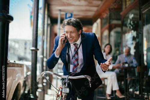 Businessman using smartphone while commuting with bike in the city