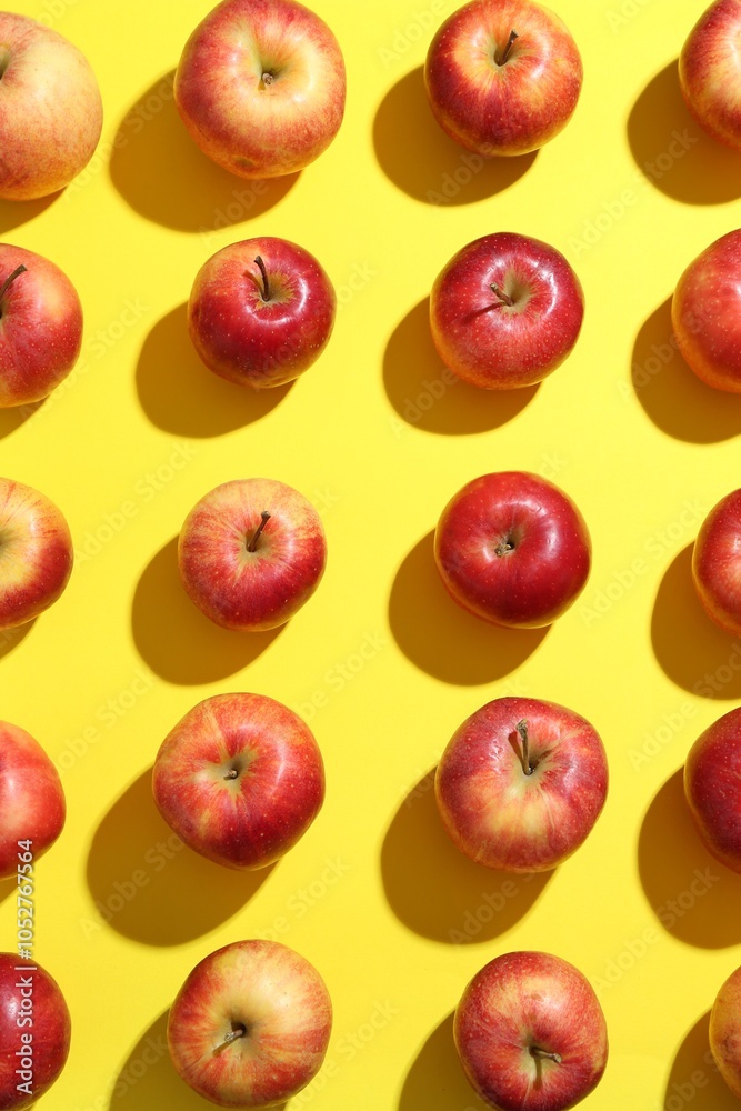 Flat lay composition with many red apples on yellow background