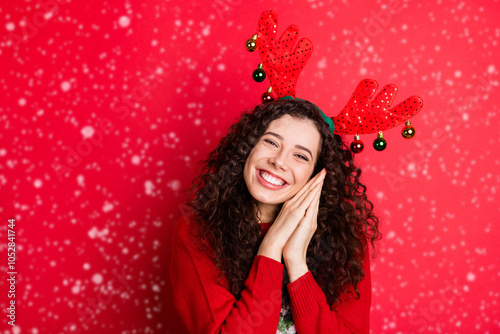 Portrait of cheerful funny funky brunette curly hair girl ready for christmas newyear party wait expect x-mas tradtion her gift present surprise wear trendy sweater isolated red color background photo