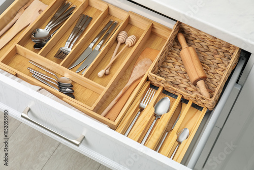 Box with cutlery in drawer, closeup. Kitchen utensils storage