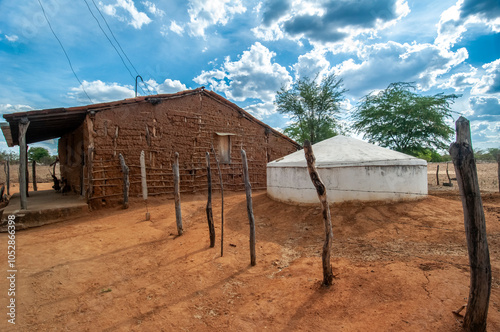 Wattle and daub house made with clay and wooden sticks, with a water cistern to withstand drought in the countryside of Paraíba, Brazil. photo