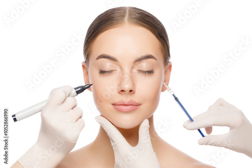 Young woman ready for beauty procedures with closed eyes. Doctors hold skin marker and injection syringe photo