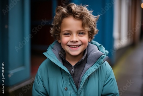 Portrait of a smiling little boy in blue jacket on the street