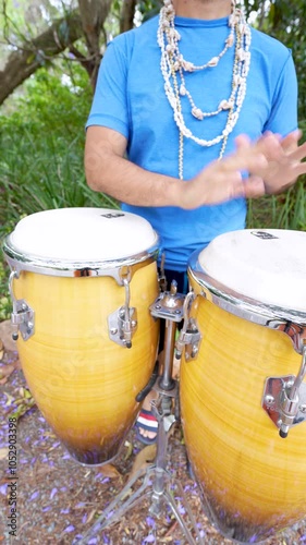 Percusionista tocando congas en formato vertical en ambiente natura