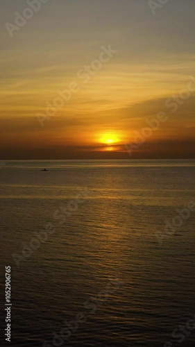 Boat running over the sea with red orange sunset sky background. Bantayan Island. Madridejos, Cebu. Philippines. Vertical view. photo