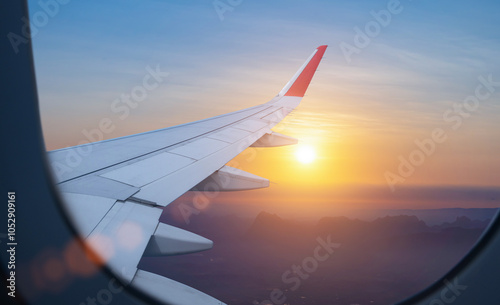 Plane wing view from airplane window inside against scenic sunset or sunrise sky background photo