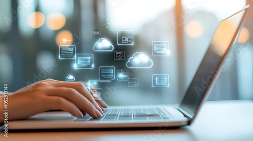 A person using cloud computing technology on their laptop, with icons of clouds and digital data flowing through them The background is blurred to emphasize the hands holding or typing 