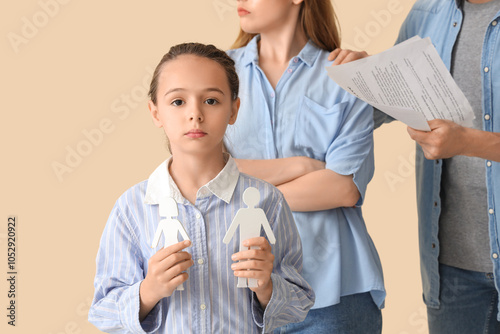 Sad little girl with family figure and her divorced parents on beige background