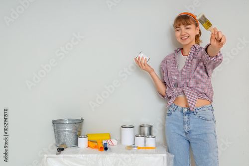Young woman with paint can ...