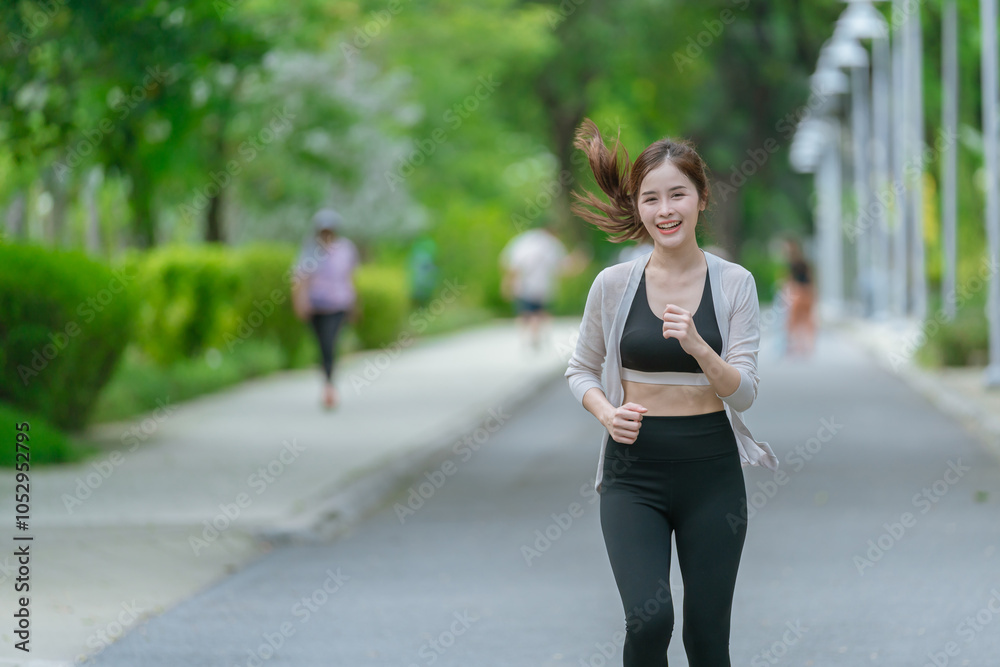 Smiling Asian woman doing sport exercises running jogging in morning park, skinny fit in sports wear outfit leggings. fitness woman running around in the park. Smiling Asian woman doing sport exercises running jogging in morning park, skinny fit in sports wear outfit leggings. fitness woman running around in the park.