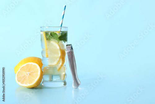 Glass of fresh lemonade with mint and fruits on blue background photo