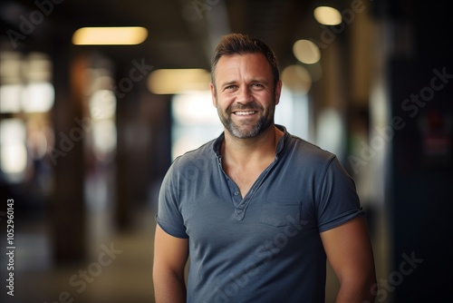 Portrait of a handsome mature man in casual clothes standing indoors.