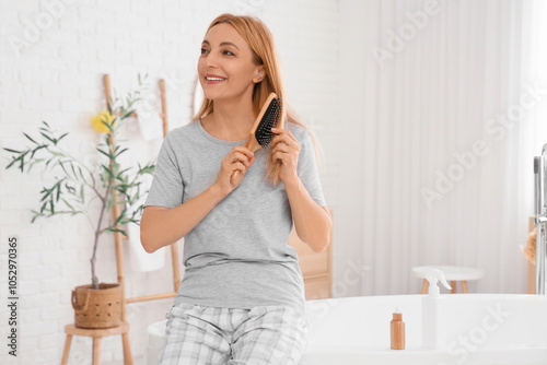 Smiling mature woman brushi...