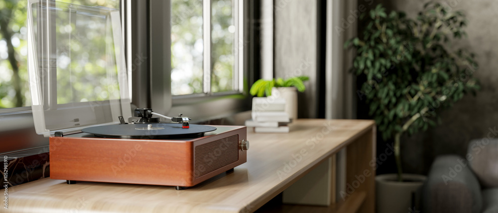 Fototapeta premium A vintage wooden record vinyl player on a wooden cabinet by the window in a contemporary living room
