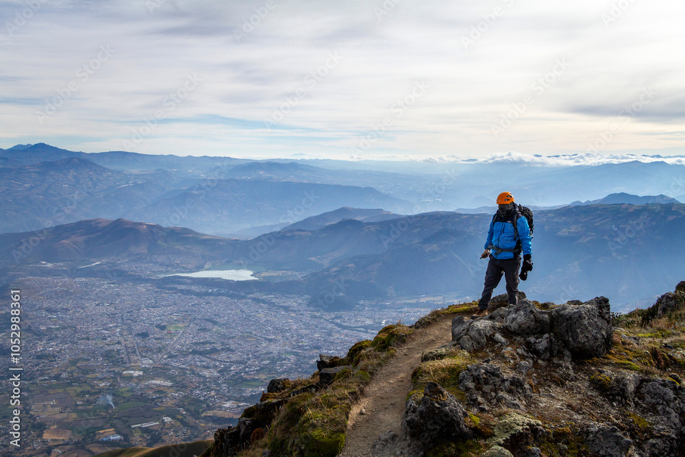 Turista en la cima del cerro imbabura de fondo la ciudad de Ibarra y laguna Yahuarcocha rodeado de montañas Turista en la cima del cerro imbabura de fondo la ciudad de Ibarra y laguna Yahuarcocha rodeado de montañas