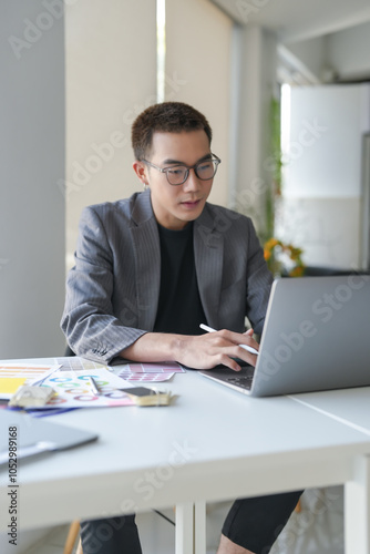 Business asian Man Artist Creative Designer sketch graphic drawing on graphic laptop and Color swatch samples Concept of idea creativity