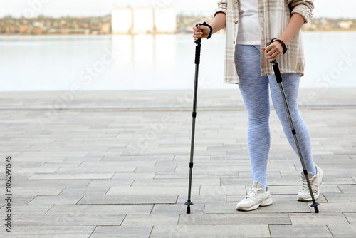 Woman nordic walking with p...