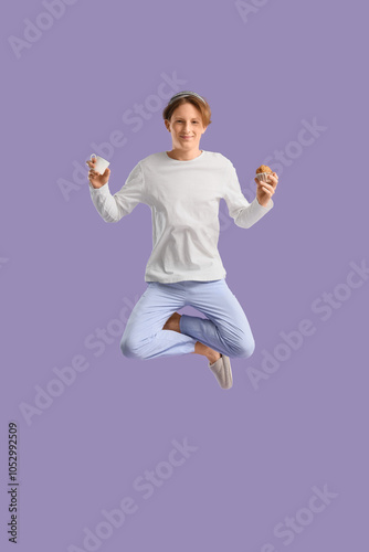 Jumping young man in pajama...