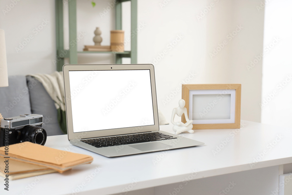 Blank laptop with frame on desk in living room, closeup Blank laptop with frame on desk in living room, closeup