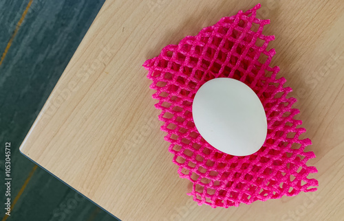 A white egg on a wood table