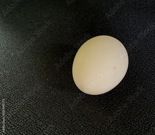 A white egg on a black table