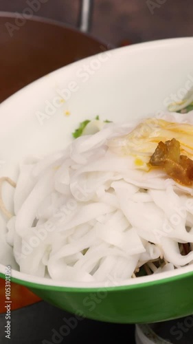 Asian street food. The process of making Vietnamese food Cao Lau this is a Vietnamese noodle bowl that includes greens, noodles, and various key ingredients. Fresh greens. photo