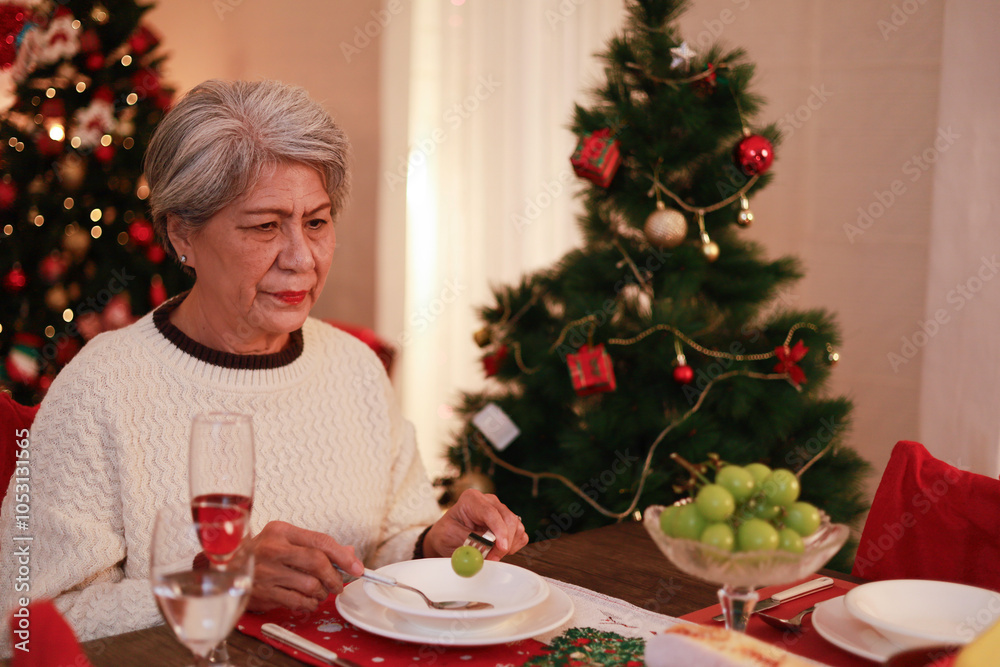 An old woman misses her family and is unhappy, sitting alone crying on Christmas Eve. An old woman misses her family and is unhappy, sitting alone crying on Christmas Eve.