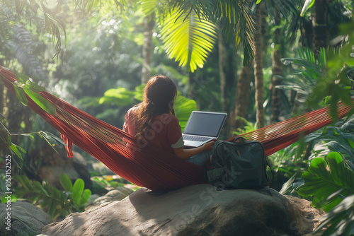 A digital nomad works remotely with a laptop in a green environtment of plants in the jungle while traveling abroad. Outdoor remote working from unique locations. photo