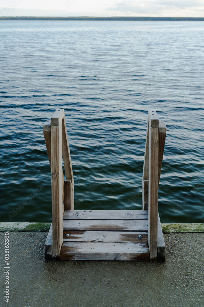 Fototapeta premium Wooden ladder into the cold blue sea