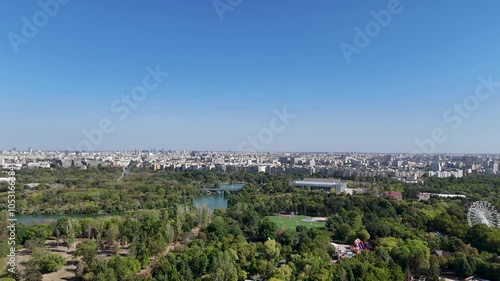 Rotating Drone View Over Oraselul Copiilor Park, Surrounded By Greenery and Lakes with Bucharest's Skyline in the Background, Romania photo