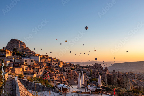 Views of Cappadocia, hot air balloons at dawn against the backdrop of tuff mountains and cave houses