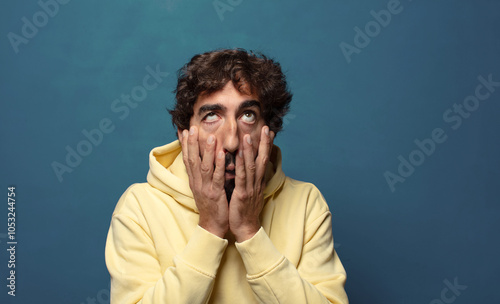 Bild auf Leinwand feeling shocked and scared, looking bored with hands on cheeks