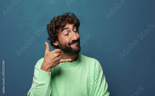 smiling cheerfully and pointing to camera while making a call you later gesture, talking on phone