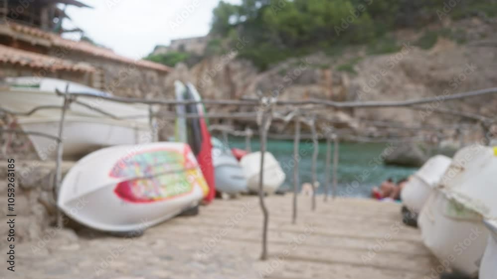 Blurred boats on a mallorca coastal shore, blurred sea in the background, outdoors under a cloudy sky Blurred boats on a mallorca coastal shore, blurred sea in the background, outdoors under a cloudy sky