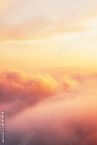 Golden clouds bathed in warm, soft sunlight create a majestic skyscape. The high-altitude view offers a serene, expansive feeling with abundant copy space.