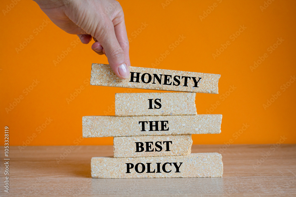 Naklejka premium Honesty is the best policy symbol. Brick blocks with words Honesty is the best policy on beautiful orange background. Businessman hand. Business, honesty best policy concept.