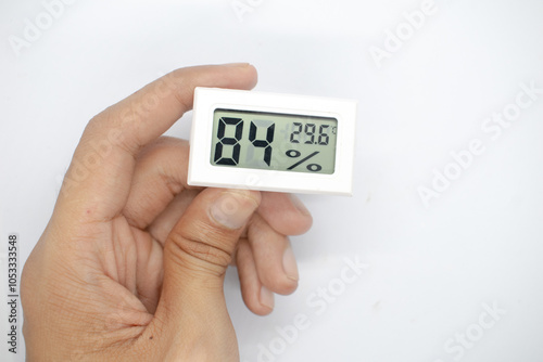 holding a humidity measuring thermometer, small size, portable, on a white background.