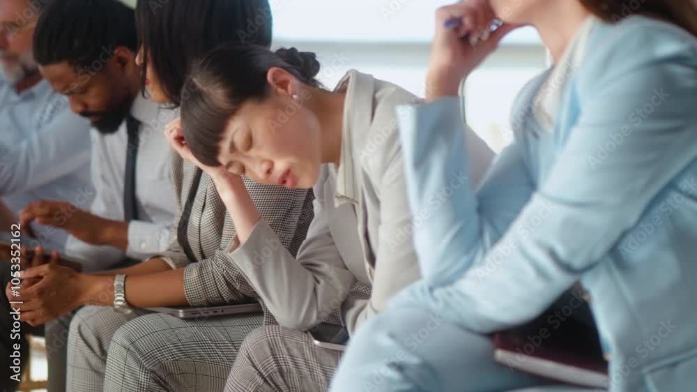 Multiethnic business group sitting in a row, waiting nervously for job interview, they are under stress, they feel anxious and worried Multiethnic business group sitting in a row, waiting nervously for job interview, they are under stress, they feel anxious and worried