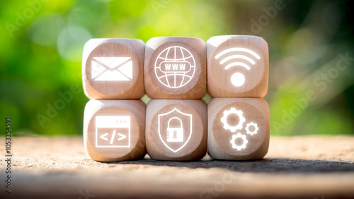 Wooden blocks displaying digital icons representing ASP.NET technology in a natural outdoor setting.