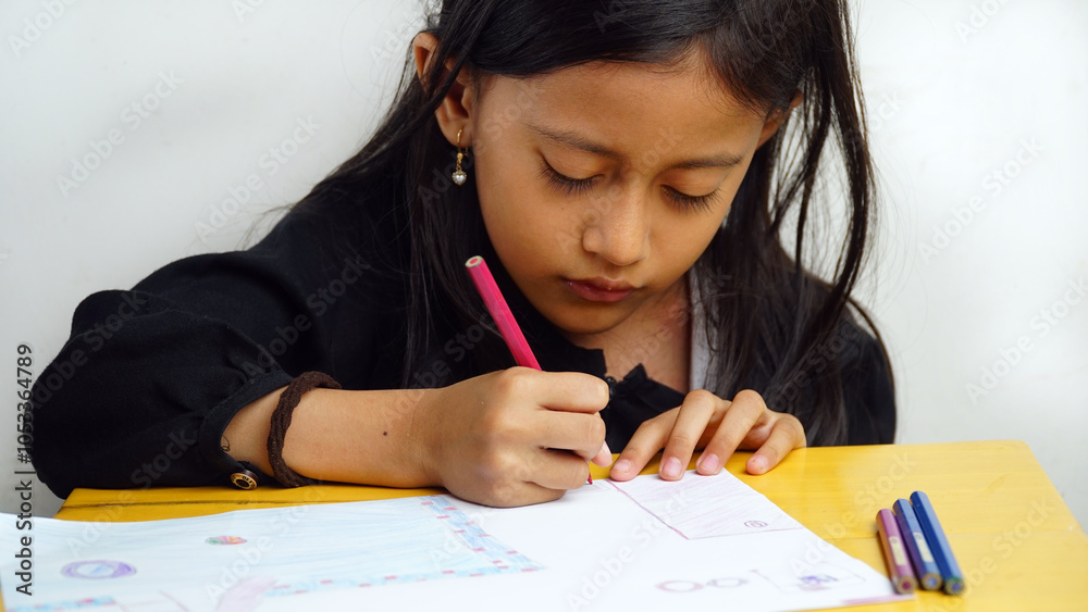 Little girl is drawing using colored pencils. Focus selected Little girl is drawing using colored pencils. Focus selected