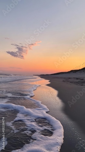Serene beach at sunset with gentle waves and soft colors in the sky.