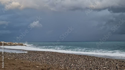 The sea before the rain, big waves, windy weather, cold, cloudy sky.