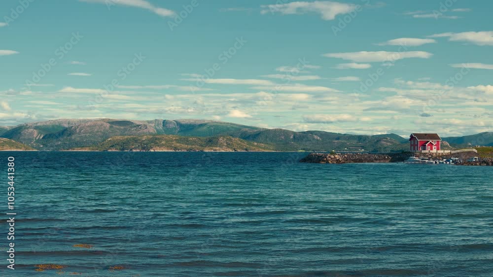 Cinemagraph of scenic red wooden house in a fjord, Norway. Blue ocean with harbor pier and boats and ships. Cinemagraph of scenic red wooden house in a fjord, Norway. Blue ocean with harbor pier and boats and ships.