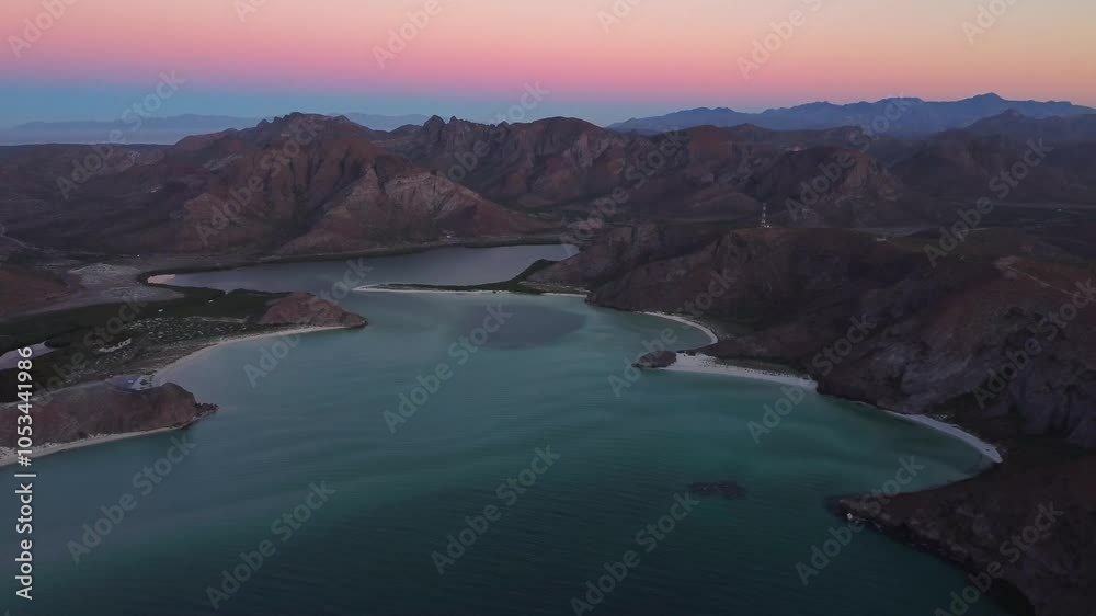 Aerial drone video of Balandra Beach during colorful sunset, mountains behind, mangroves and blue water, La Paz, Baja California Sur, México Aerial drone video of Balandra Beach during colorful sunset, mountains behind, mangroves and blue water, La Paz, Baja California Sur, México