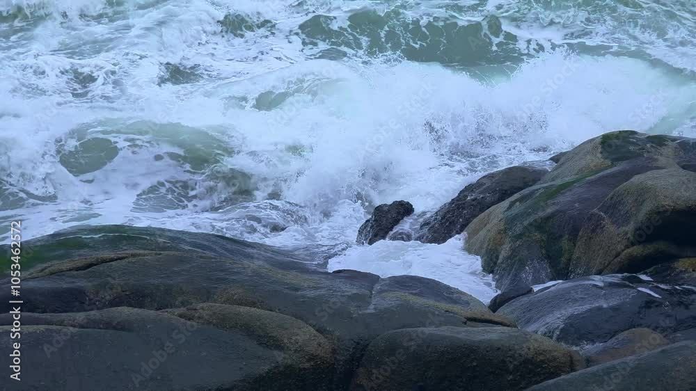Dynamic waves crashing vigorously against rugged and steadfast rocks Dynamic waves crashing vigorously against rugged and steadfast rocks