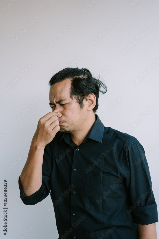 Person closing their nose with fingers, reacting to an unpleasant smell Person closing their nose with fingers, reacting to an unpleasant smell