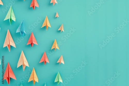 colorful paper airplanes flying on a turquoise background, representing creativity and innovation, perfect for modern design concepts and educational themes photo