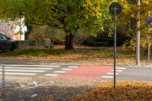 Pedestrian crosswalk surrounded by vibrant autumn trees with golden leaves on quiet city street, highlighting beauty of fall in urban landscape. Concept safety, and urban nature. High quality photo photo