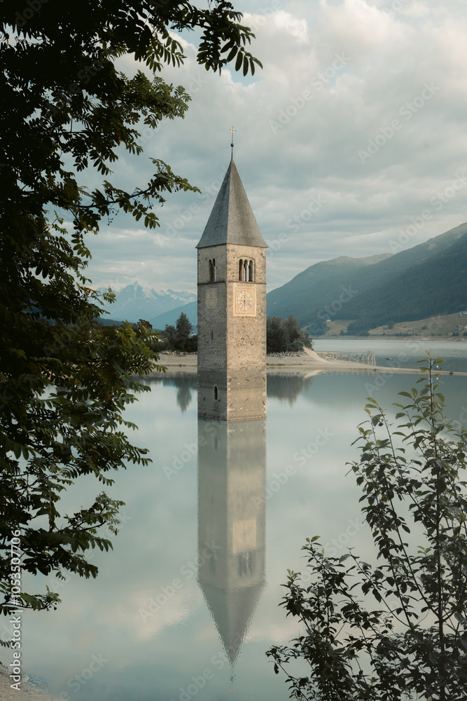 Church tower of Graun at Reschensee lake in Curon Venosta, South Tyrol, Italy
